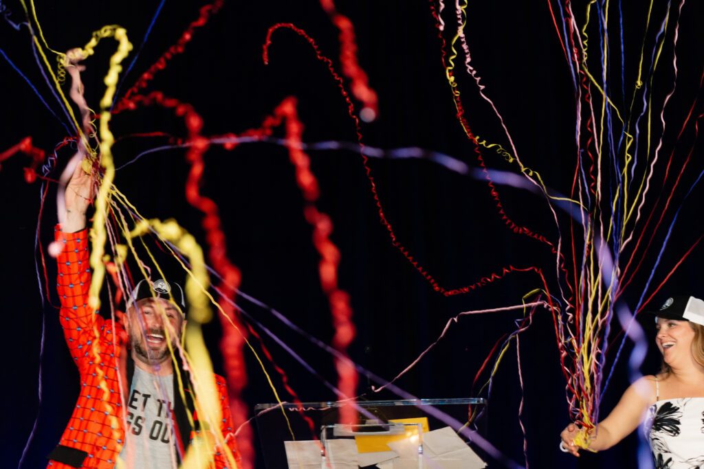 Emcees for the event, Miles Huff with the City of Chattanooga and Terran Anderson with United Way, pop confetti poppers on stage to celebrate award winners and end the ceremony.